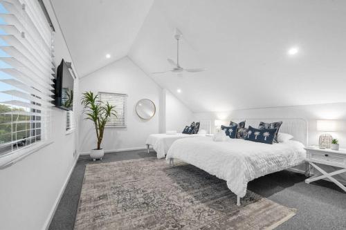 a white bedroom with two beds and a rug at Ocean View Villa, 2 bedroom in Mandurah
