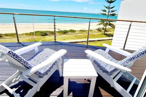two chairs and a table on a deck with the beach at Ocean View Villa, 2 bedroom in Mandurah