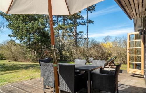 una mesa y sillas en una terraza con sombrilla en Stunning Home In Fårevejle With Wifi, en Fårevejle