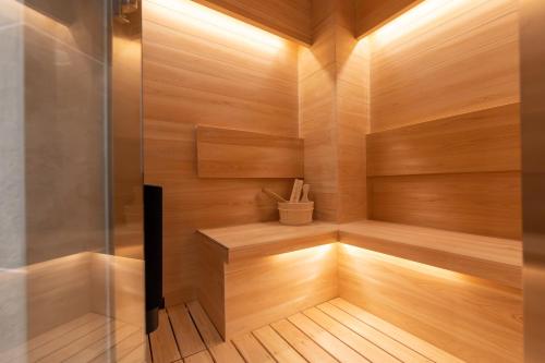 a sauna with wood paneling and a glass wall at ONE WORLD Sakaisuji Honmachi in Osaka