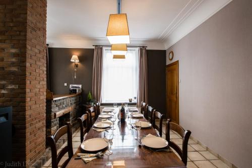 a long dining room with a long table and chairs at Maison spacieuse unifamiliale. Gîte La Clochette in Bastogne