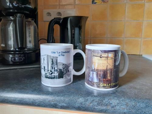 two coffee mugs sitting on top of a counter at Maison spacieuse unifamiliale. Gîte La Clochette in Bastogne