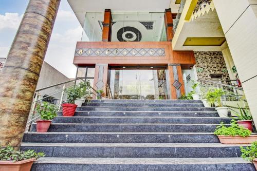 un escalier en face d'un bâtiment avec des plantes en pot dans l'établissement Townhouse OAK Hind Palace Near Gomti Riverfront Park, à Vibhuti Khand