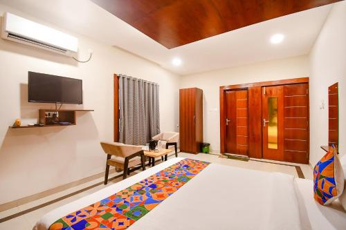 a hotel room with a bed and a tv at FabHotel Greenland Grand - Nr Kalinga Stadium in Bhubaneshwar