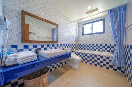 a blue and white bathroom with a sink and a toilet at Tian Nian B&B in Jiaoxi