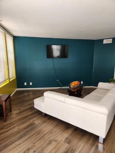 MARINA DEL REY BEAUTY في لوس أنجلوس: غرفة معيشة مع أريكة بيضاء وجدار أزرق