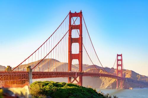 a red bridge over water with mountains in the background at Stunning Oceanview Coastal Home Beach Trails Family Activities in Montara