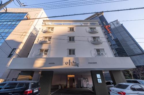 a large white building with cars parked in front of it at The Hyoosik Aank Hotel Daejeon Yongjeon 1st Branch in Daejeon