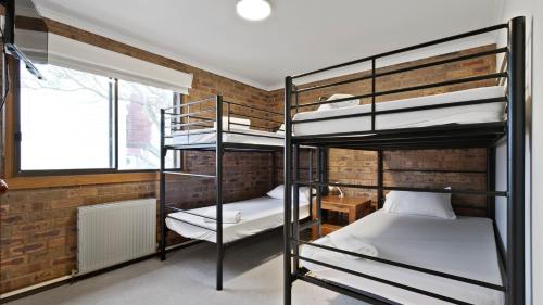 two bunk beds in a room with a brick wall at Lawlers 17 in Mount Hotham