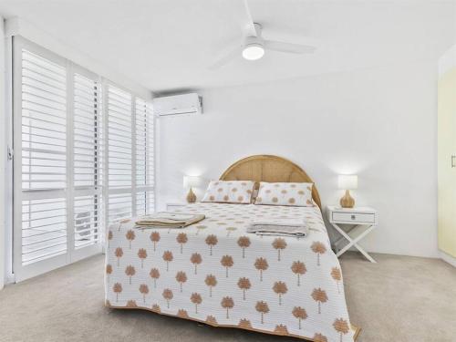 a white bedroom with a bed and a window at Kawana Beachside Getaway 1 Bedroom Apartment in Buddina