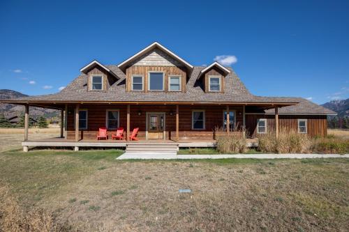 a large wooden house with red chairs on a porch at Alpine Airspace by KABINO Airpark Foosball Garage Satellite in Alpine