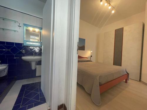 una camera con letto e un bagno con lavandino di Casa Riviera a San Vito lo Capo