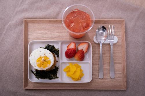 a tray of food with an egg and fruit on it at Aank Hotel Daejeon Yongjeon 1st in Daejeon
