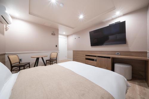 a hotel room with a bed and a flat screen tv at Aank Hotel Daejeon Yongjeon 1st in Daejeon
