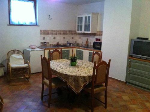 a kitchen with a table and chairs and a kitchen with a table and a tv at Ospitaci Appartamenti di campagna Le Rancole in Valtopina