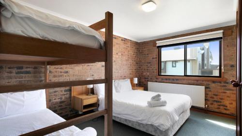 a bedroom with two bunk beds and a window at Lawlers 31 in Mount Hotham