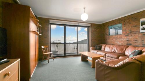 a living room with a couch and a large window at Lawlers 31 in Mount Hotham