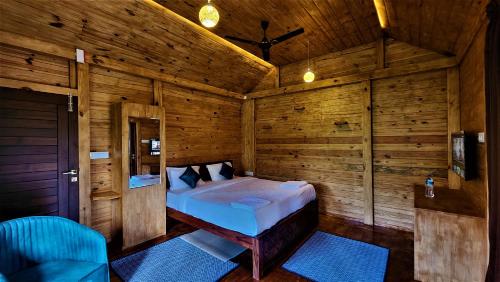 1 dormitorio con 1 cama en una habitación de madera en Coorg Bliss Estate Stay en Madikeri