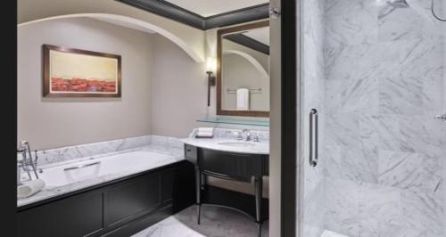 a bathroom with a tub and a sink and a shower at Bachelor Gulch Ritz-carlton 1 Bedroom Mountain Residence With Ski In, Ski Out Access, Hot Tub, And Full Service Spa in Avon