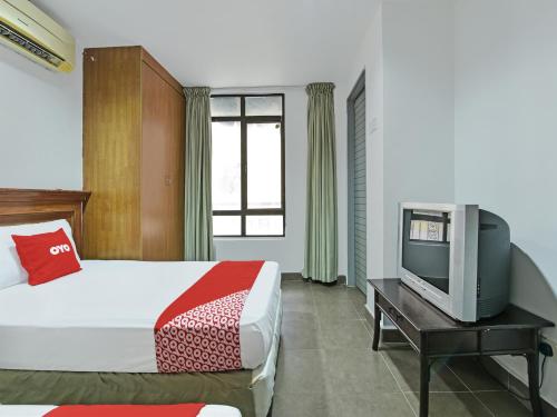 吉隆坡的住宿－Super OYO 90780 J Hotel Bukit Bintang，一间酒店客房,配有一张床和一台电视