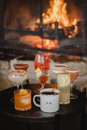 a group of drinks on a table in front of a fireplace at Peppers Cradle Mountain Lodge in Cradle Mountain