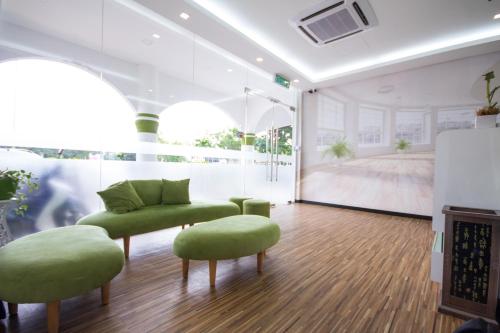 a room with two green chairs and a couch at S Hotel Seberang Jaya in Perai