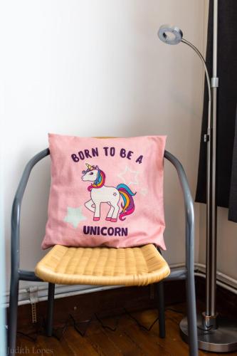 a pink unicorn pillow on a chair with a lamp at Maison spacieuse unifamiliale. Gîte La Clochette in Bastogne