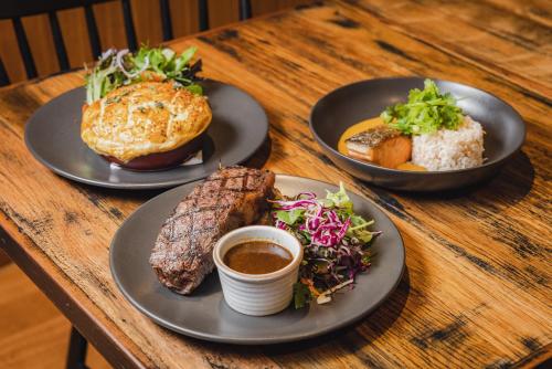 three plates of food on a wooden table at Peppers Cradle Mountain Lodge in Cradle Mountain