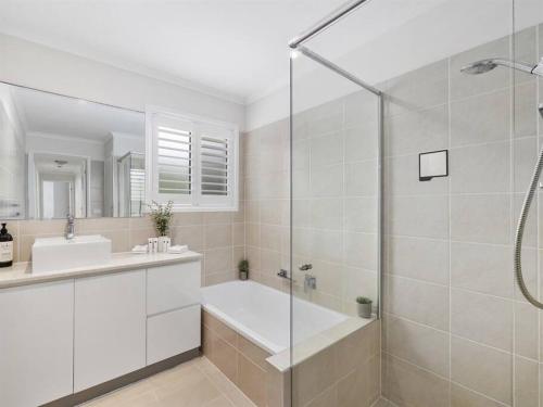 Buddina的住宿－Buddina Deluxe 3 Bedroom Family Getaway House，带淋浴、浴缸和盥洗盆的浴室