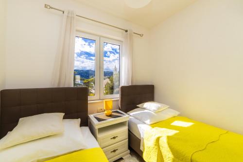 a bedroom with two twin beds and a window at Apartment Karlo - Ploče, Croatia in Ploče