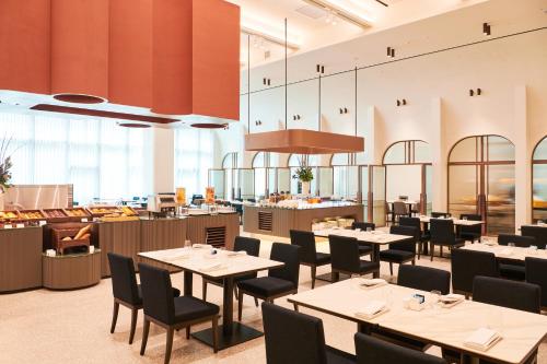 a restaurant with tables and chairs and a counter at Nine Tree Premier ROKAUS Hotel Seoul Yongsan in Seoul