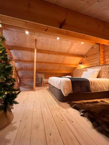 Cette chambre comprend un lit et un arbre de Noël. dans l'établissement Chalet Le Montagnard SPA & SAUNA - Lits faits - Serviettes - Peignoirs - Ménage inclus, à Rochesson