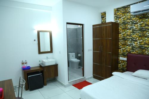 a bedroom with a bathroom with a shower and a sink at Kurianplackal Residency in Alwaye