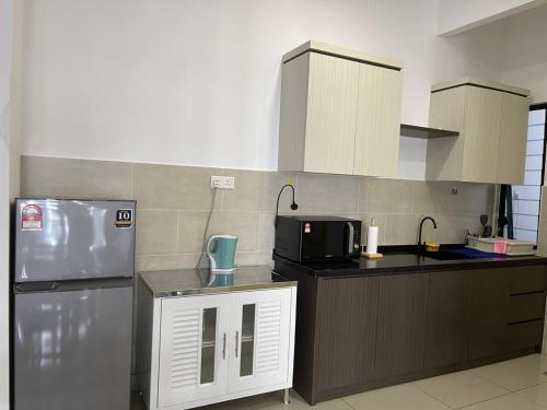a kitchen with a refrigerator and a microwave at Atlantis Residence Batik Travel in Tranquerah