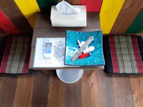 a table with a cell phone and other items on it at backpackers guesthouse Border in Nago