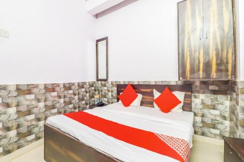ein Schlafzimmer mit einem Bett mit roten Kissen darauf in der Unterkunft Hotel Dolphin in Lucknow