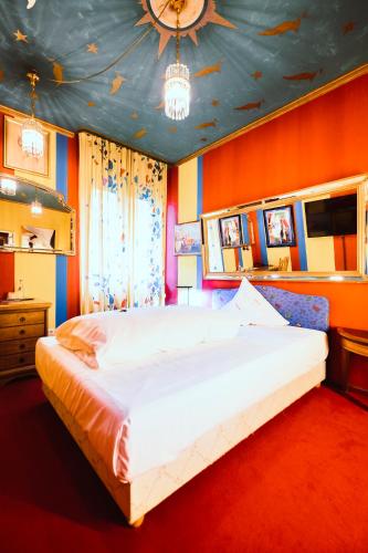 a bedroom with a large bed with an orange wall at Design Hotel Euskirchen in Euskirchen