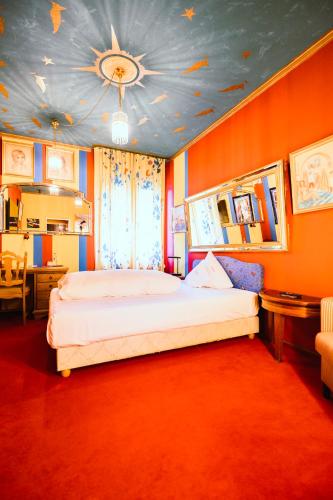 a bedroom with a large bed with an orange wall at Design Hotel Euskirchen in Euskirchen