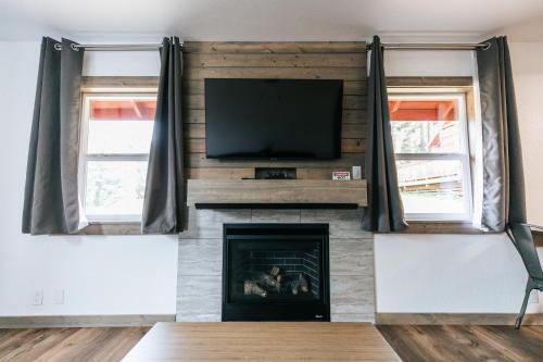 a living room with a fireplace with a flat screen tv at View Crest Lodge in Trinidad