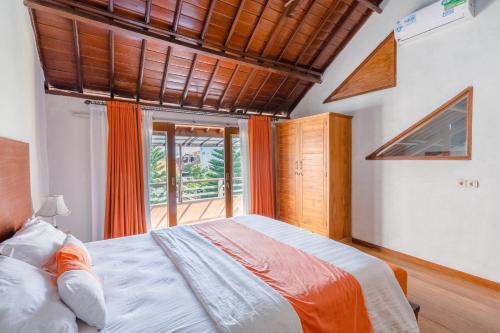 a bedroom with a large bed and a large window at Villa Padma by Best Deals Asia Hospitality in Nusa Dua
