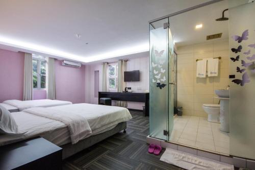 a bedroom with a bed and a bathroom with a shower at S Hotel Seberang Jaya in Perai