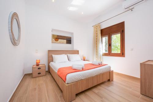 a bedroom with a bed and a window and a television at Villa Estrella in Aegina Town