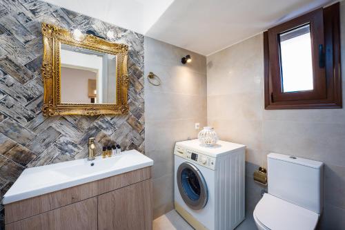 ein Badezimmer mit einer Waschmaschine und einem Waschbecken in der Unterkunft Villa Estrella in Ägina Stadt