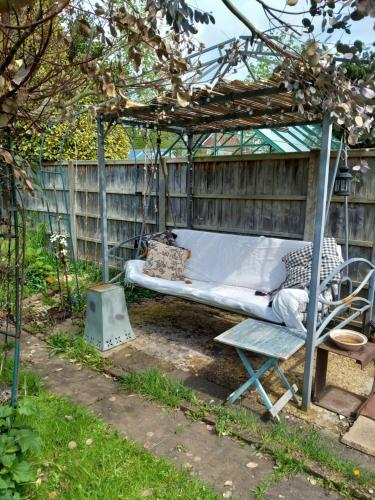a swinging bed and a chair in a garden at Escape to the Country in wonderful Worcestershire in Ombersley
