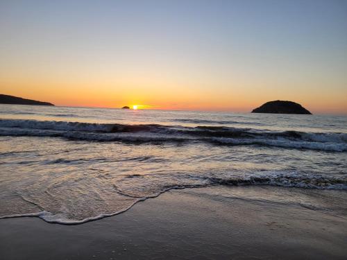 einen Sonnenuntergang am Strand mit dem Meer in der Unterkunft Bungalows Maria Teresa in Rincón de Guayabitos