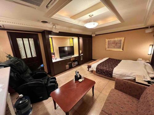 a hotel room with a bed and a couch and a table at HOTEL ULURU in Kobe