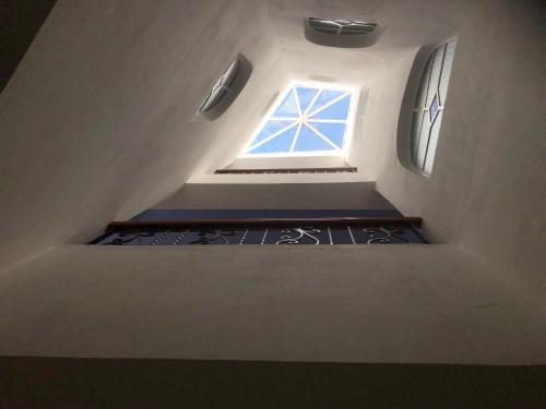 a small attic room with a window and stairs at Dar Fatima in Chefchaouene