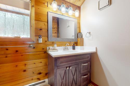 a bathroom with a sink and a mirror at Mountain View Chalet in West Dover