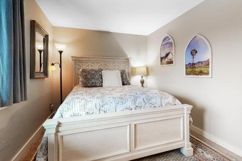 a bedroom with a white bed and two windows at Mountain View Chalet in West Dover