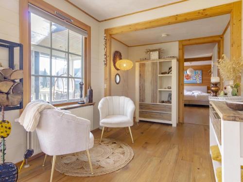 a living room with two chairs and a bedroom at Holiday Home by Zuidlaardermeer Jetty in Kropswolde